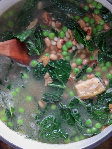 Black-eyed pea, bacon, and kale soup in a large pot.