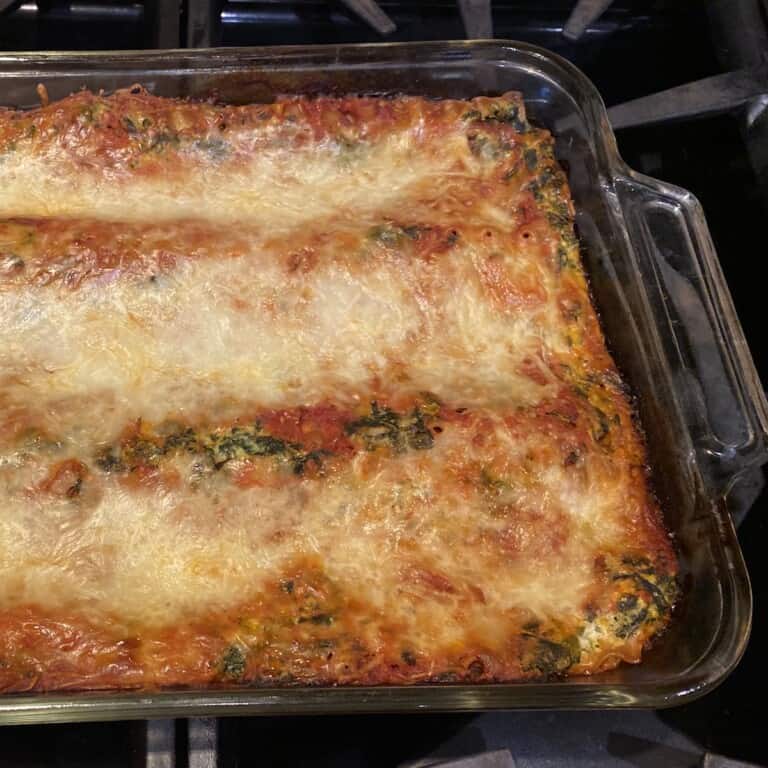 Spinach Lasagna in a clear baking dish on a stove top