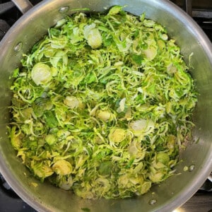 Shaved sauteed Brussels sprouts in a sautee pan.