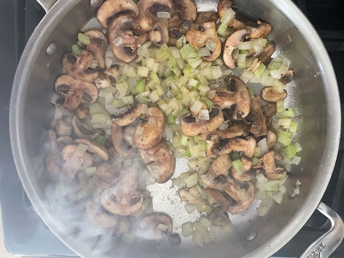 Satued onion, celery, and mushroooms in a saute pan