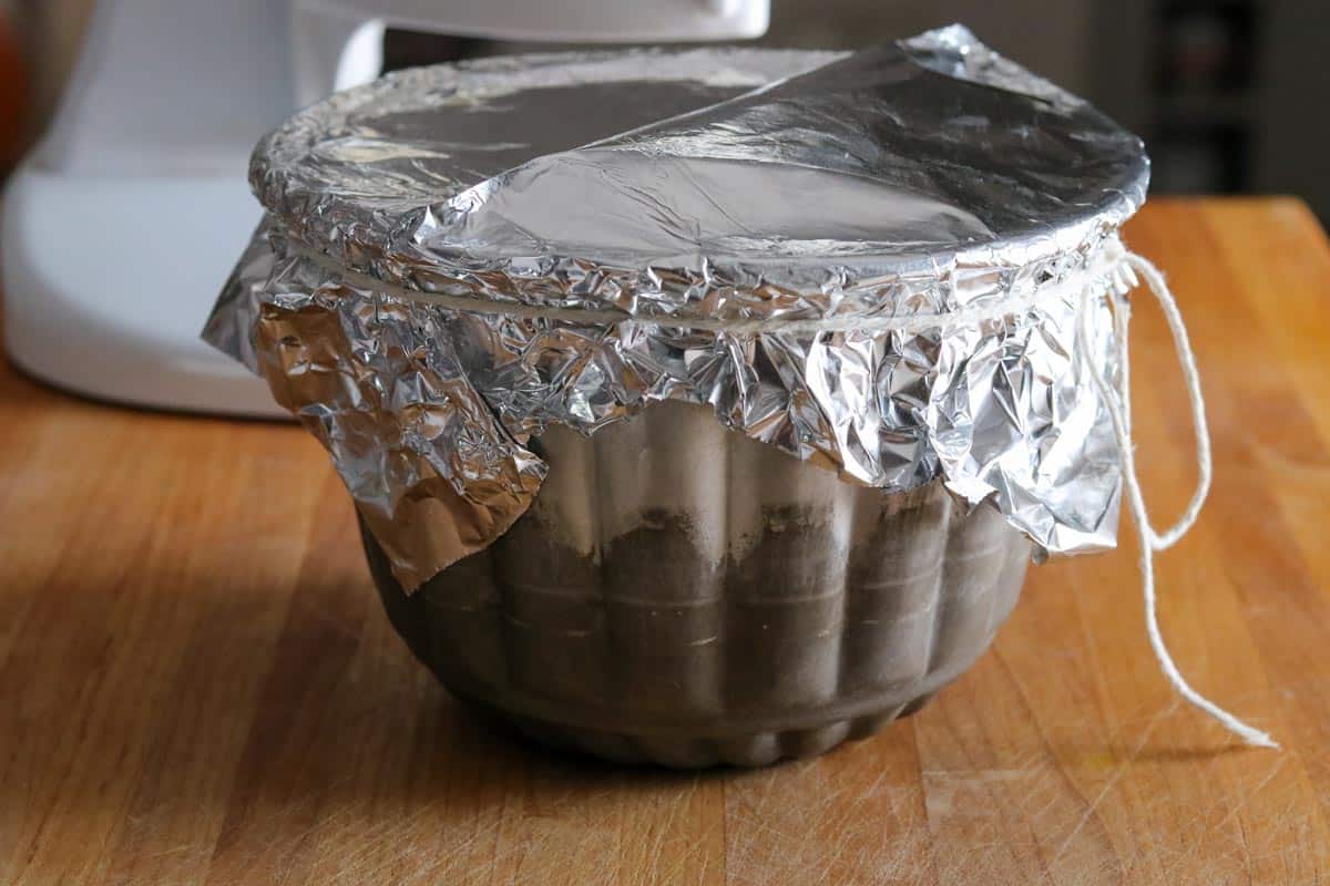 Pudding mold with aluminum foil lid tied on with butcher's twin. 