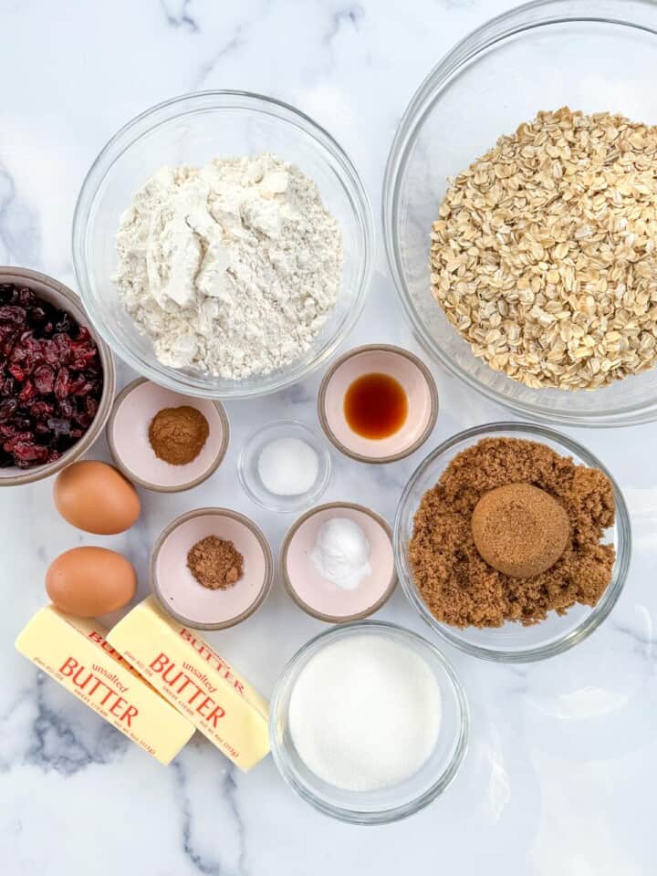 Ingredients in an assortment of bowls to make oatmeal craisins cookies. 