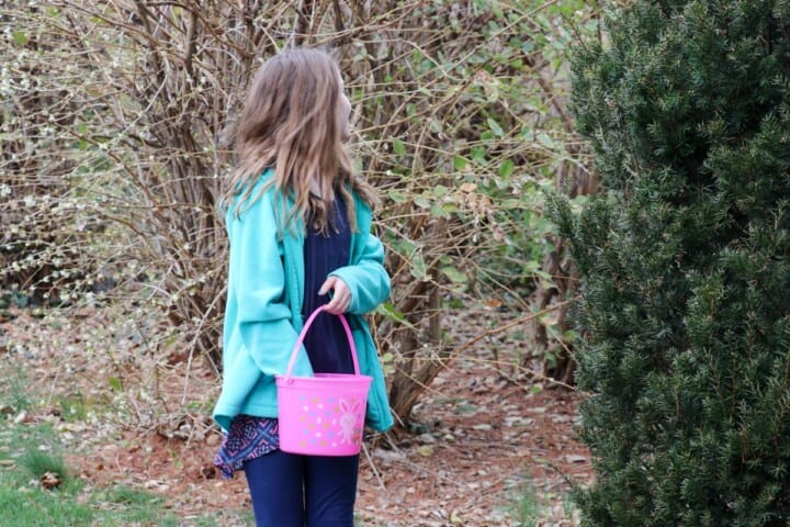 Older elementary aged child with long dark blond hair searching for Easter eggs.